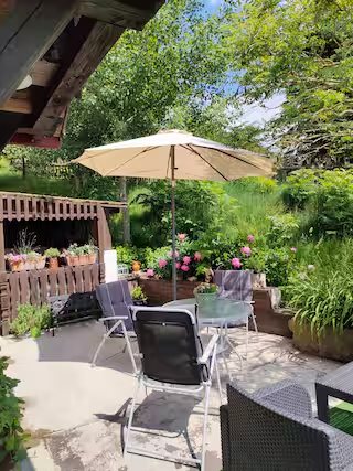 Wohnung 1: Terrasse mit Sonnenschirm und Gartenmöbeln