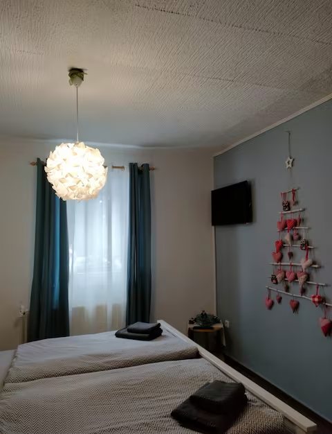 Wohnung 2: Schlafzimmer mit Doppelbett und Hängeleuchte